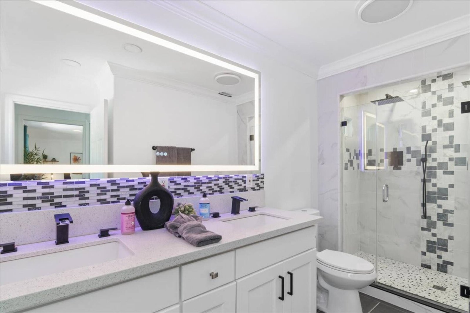 Bagno con specchio retroilluminato e doccia con box in vetro