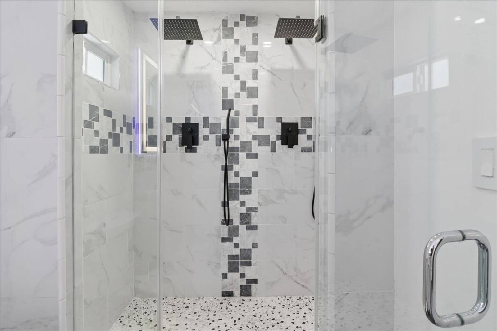 Doccia in vetro con soffione a pioggia e piastrelle decorate
