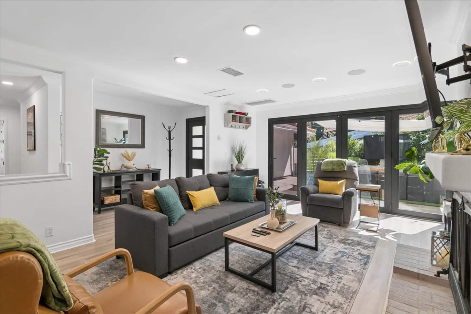 Living room with gray sofas, a wood coffee table, and doors opening to the backyard